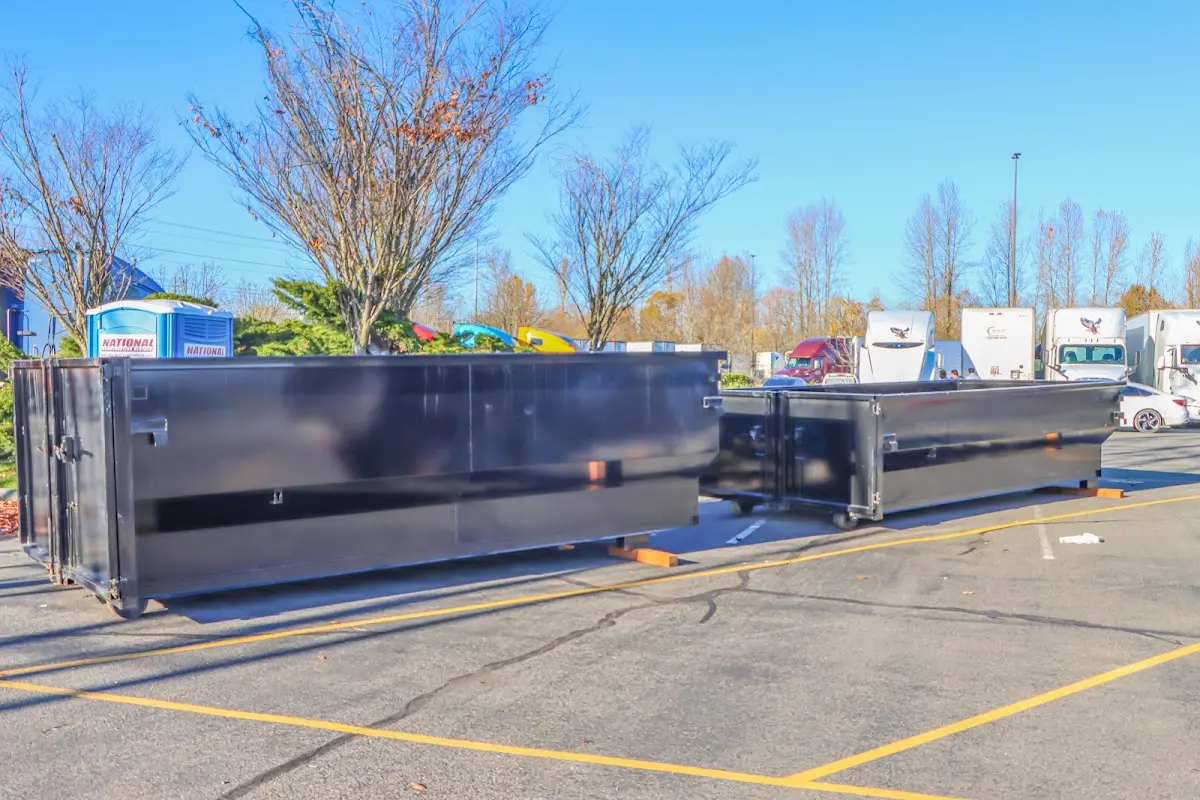 Professional dumpster rental service with roll-off container on residential driveway in Prospect